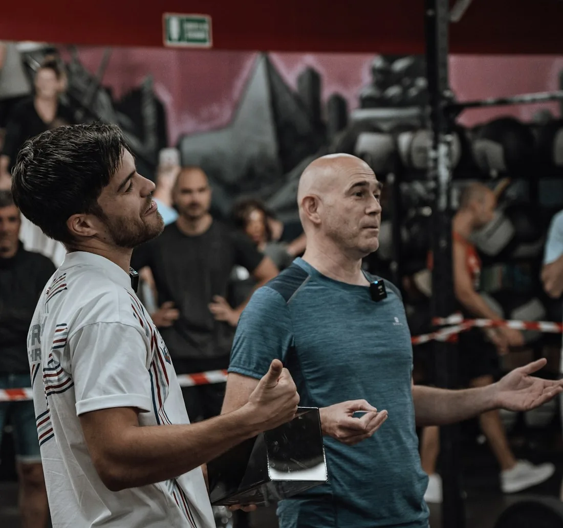 Deux coachs échangent au milieu de leur salle de sport